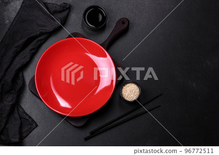 Empty plate with wooden sticks for Asian food on a dark concrete background 96772511