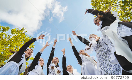 Happy Russian school graduates are stretching their hands on their last school day. 96772799
