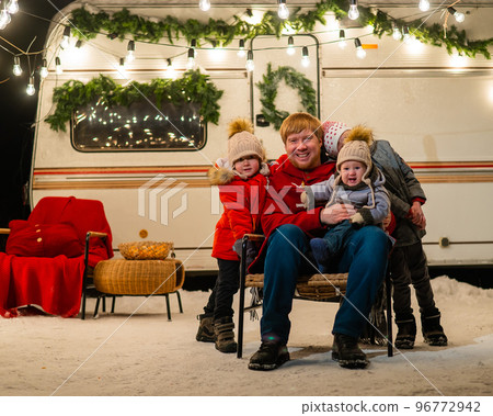 Caucasian man and three sons celebrate Christmas in a mobile home. 96772942