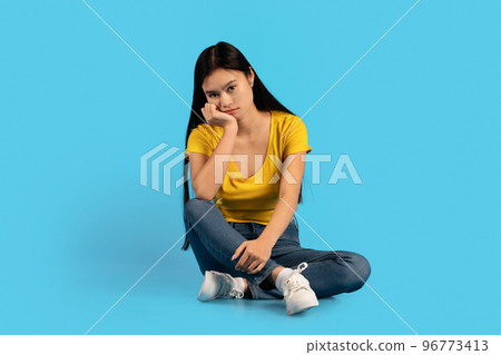 Sad upset tired millennial korean woman student sitting on floor, suffering from pressure and overwork Sad upset tired millennial korean woman student sitting on floor, suffering from pressure and overwork 96773413