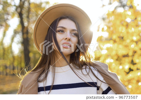 portrait of attractive stylish smiling portrait of attractive stylish smiling woman with long hair walking in the park, dressed in warm brown coat autumn trendy fashion, street style wearing hat portrait of attractive stylish smiling portrait of attractive stylish smiling woman with long hair walking in the park, dressed in warm brown coat autumn trendy fashion, street style wearing hat 96773507