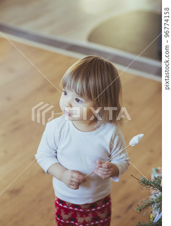 Adorable baby playing with magic wand near christmas tree Adorable baby playing with magic wand near christmas tree 96774158