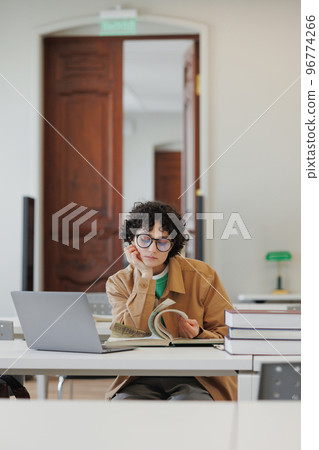 young woman in a library or coworking works on a laptop online, education and work on a creative project or diploma young woman in a library or coworking works on a laptop online, education and work on a creative project or diploma 96774266