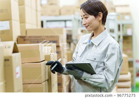 Female worker taking inventory in the warehouse 96775275