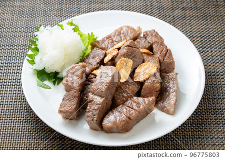 Bite-sized steak served with grated daikon radish. 96775803