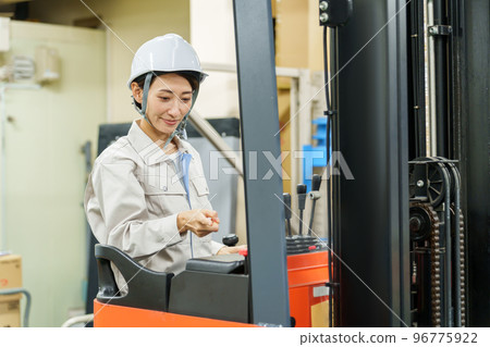 Female worker driving a forklift 96775922