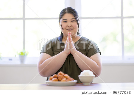 A woman eating rice 96777088
