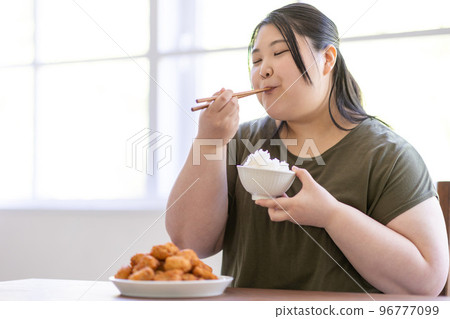 一個女人吃米飯 96777099