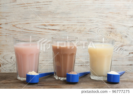 Protein shakes and powder on wooden table 96777275