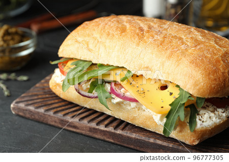 Delicious sandwich with fresh vegetables and cheese on grey table, closeup 96777305