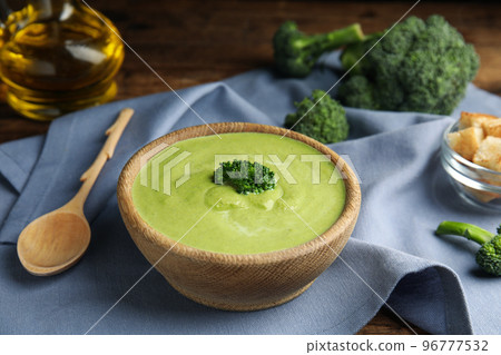 Delicious broccoli cream soup served on wooden table 96777532