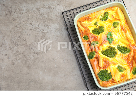 Tasty broccoli casserole in baking dish on cooling rack, top view. Space for text Tasty broccoli casserole in baking dish on cooling rack, top view. Space for text 96777542