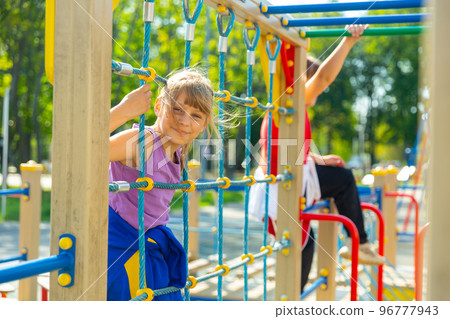 Two active teenage girls are on the playground 96777943