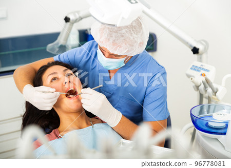 Dentist examining asian female patient teeth Dentist examining asian female patient teeth 96778081