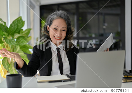 Cheerful Asian aged businesswoman having an online meeting with board members 96779564