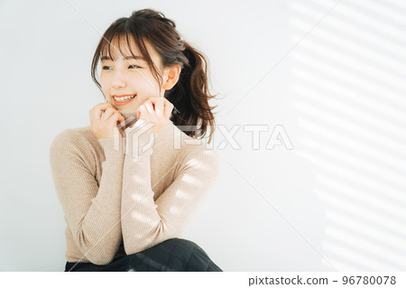 Smiling woman wearing turtleneck knit 96780078