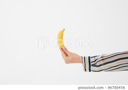 Hand holding a banana White background 96780456