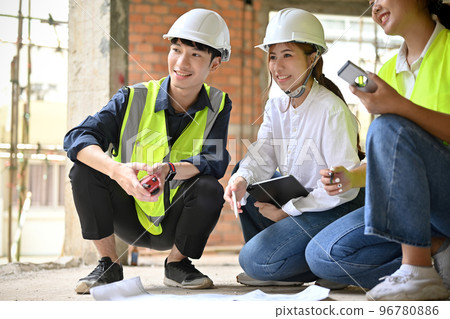 Female architect having a meeting with her civil engineer at the construction site. 96780886