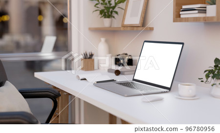 Notebook laptop mockup is on a modern white office desk with decor accessories. close-up 96780956