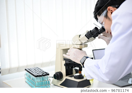 Talented Asian male scientist or chemist looking under the Microscope, working in the lab. 96781174