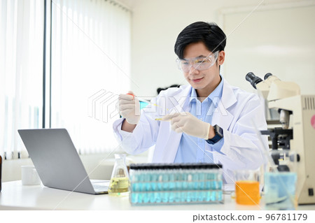 Handsome Asian male scientist adjusts a virus sample in a Petri dish in his science lab. Handsome Asian male scientist adjusts a virus sample in a Petri dish in his science lab. 96781179