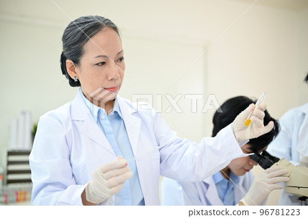 Professional Asian-aged female scientist working in the laboratory with her team 96781223