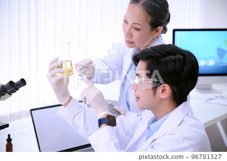 Smart young Asian male scientist working and brainstorming with his senior female in the lab. 96781327