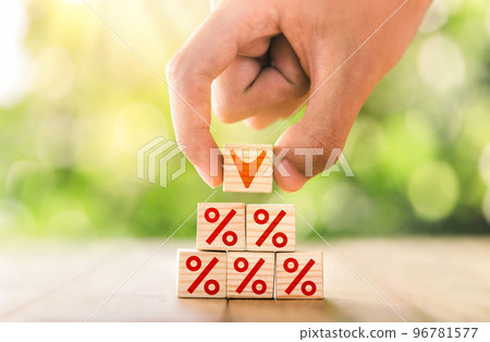 Hand arranged stacked wooden blocks for a step ladder with percentage sign and down arrow symbol. Mortgage rates business, Interest rate financial and mortgage rates concept. Hand arranged stacked wooden blocks for a step ladder with percentage sign and down arrow symbol. Mortgage rates business, Interest rate financial and mortgage rates concept. 96781577