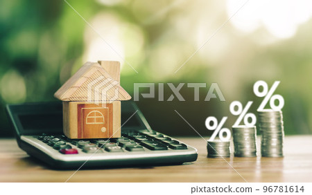 House is placed on the calculator and coins placed on table. along with interest concept of calculating interest payments. 96781614