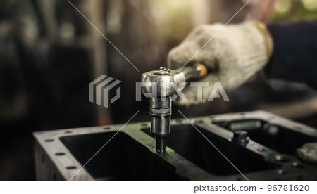Auto mechanic working on car engine in mechanics garage. Repair service. Car care maintenance and servicing. 96781620