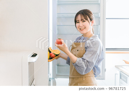 媽媽、家庭主婦、管家、家政代理亞洲女人從冰箱裡拿出西紅柿 96781725