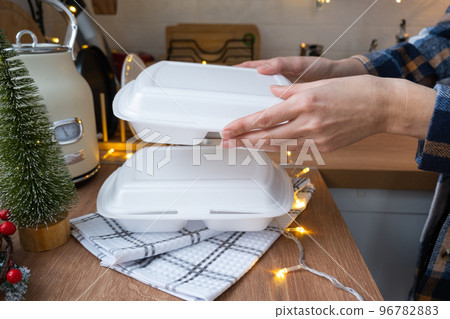 Food delivery service containers on table white scandi festive kitchen in christmas decor. Eve New year, saving time, too lazy to cook, hot order, disposable plastic box in fairy light. mock up Food delivery service containers on table white scandi festive kitchen in christmas decor. Eve New year, saving time, too lazy to cook, hot order, disposable plastic box in fairy light. mock up 96782883