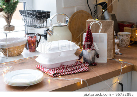 Food delivery service containers on table white scandi festive kitchen in christmas decor. Eve New year, saving time, too lazy to cook, hot order, disposable plastic box in fairy light. mock up Food delivery service containers on table white scandi festive kitchen in christmas decor. Eve New year, saving time, too lazy to cook, hot order, disposable plastic box in fairy light. mock up 96782893