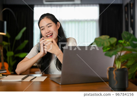 Happy young Asian female enjoys talking on the phone with her boyfriend. Happy young Asian female enjoys talking on the phone with her boyfriend. 96784156
