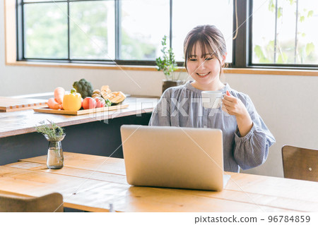 A housewife Asian woman who uses a computer at home for online shopping, SNS, chatting, and playing games 96784859