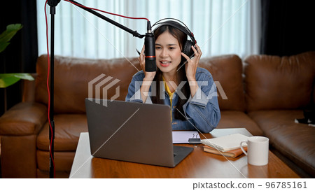 Attractive Asian female freelance podcast radio host running her show from her living room 96785161
