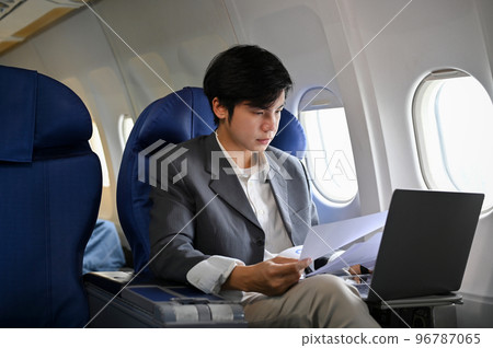 Professional and successful Asian businessman working during the flight for his business trip. Professional and successful Asian businessman working during the flight for his business trip. 96787065