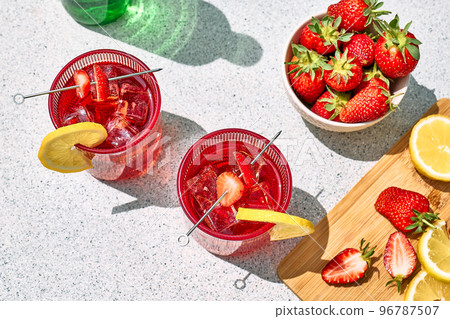 Fresh summer strawberry cocktail or mocktail on the table in the garden. Sparkling pink strawberry lemonade. Fresh summer strawberry cocktail or mocktail on the table in the garden. Sparkling pink strawberry lemonade. 96787507