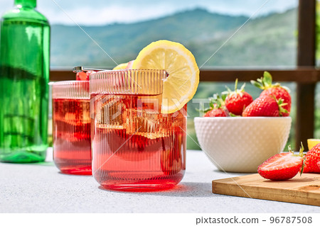 Fresh summer strawberry cocktail or mocktail on the table in the garden. Sparkling pink strawberry lemonade. Fresh summer strawberry cocktail or mocktail on the table in the garden. Sparkling pink strawberry lemonade. 96787508
