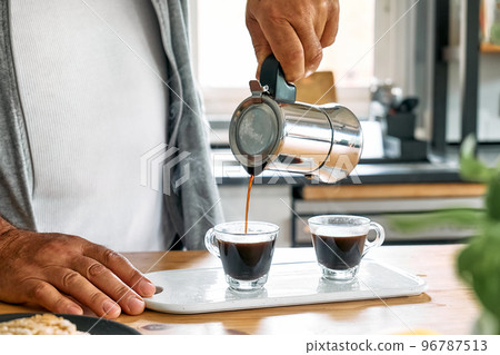 Man preparing classic Italian coffee in the mocha in the kitchen. Coffee brake. Morning habit. Man preparing classic Italian coffee in the mocha in the kitchen. Coffee brake. Morning habit. 96787513