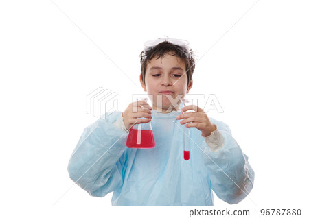 Student in practical classes in chemistry. Smart teenage boy holds flask and test tube with red liquid with reagents. Demonstration of chemical experiments at school, isolated over white background Student in practical classes in chemistry. Smart teenage boy holds flask and test tube with red liquid with reagents. Demonstration of chemical experiments at school, isolated over white background 96787880