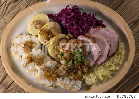 smoked meat served with red and white cabbage and two kinds of dumplings smoked meat served with red and white cabbage and two kinds of dumplings 96789708