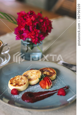 Cottage cheese pancakes or syrniki on a plate Cottage cheese pancakes or syrniki on a plate 96790109