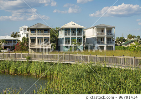 Destin, Florida- Boardwalk with wood railings above the lake waterfront of a residential area 96791414