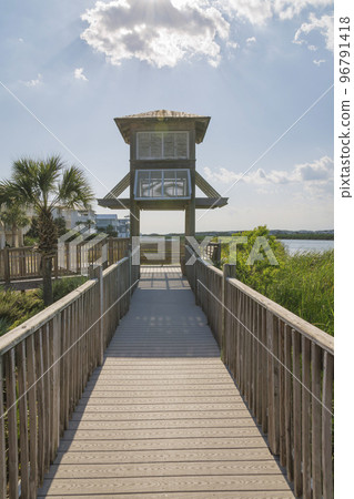 Destin, Florida- View of a small house roof over the boardwalk on a lake 96791418