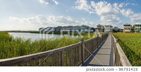 Boardwalk with wooden railings over the tall grasses in a lake near the residences at Destin, FL Boardwalk with wooden railings over the tall grasses in a lake near the residences at Destin, FL 96791419