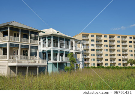 Destin, Florida- View of three-storey houses with view deck and apartment building with balconies 96791421