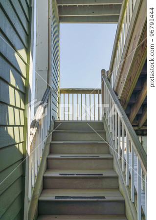 Navarre, Florida- Narrow staircase near the wall with painted wood lap sidings 96791444