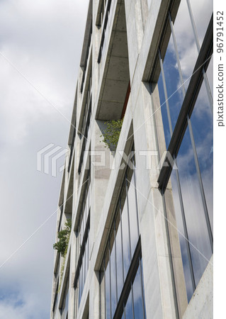 Building with plants on the open windows and reflection of the sky at the glass in Miami, FL 96791452
