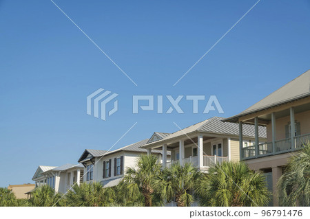 Palm trees at the front of the row of houses against the blue sky at Destin, Florida Palm trees at the front of the row of houses against the blue sky at Destin, Florida 96791476